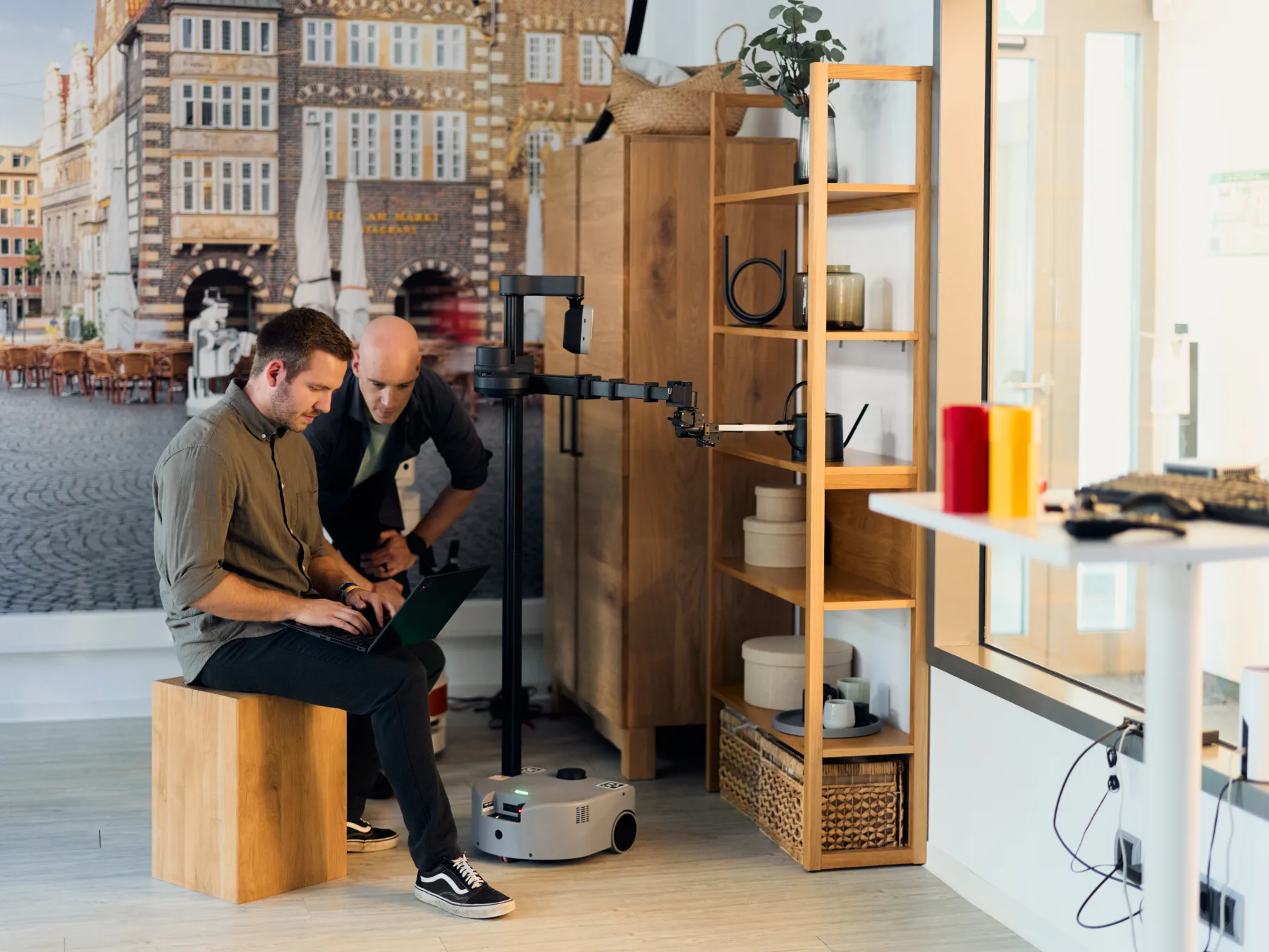 Two researchers configuring a mobile service robot in a domestic laboratory